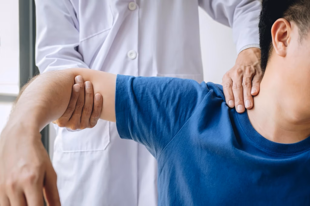 Der Orthopäde untersucht einen Patienten mit Schulterschmerzen.